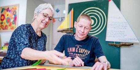 Kreativtherapie Therapeutin und Patient basteln zusammen in der Kreativtherapie