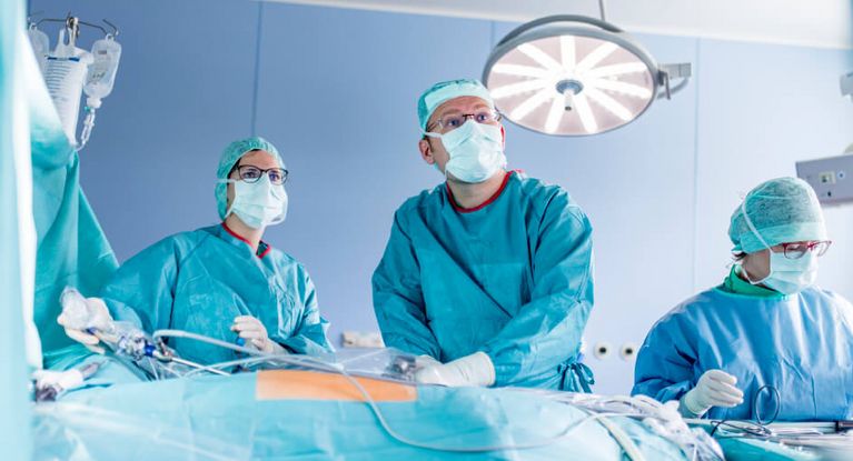 Ärzte und Pflegekräfte arbeiten bei einer Operation eng zusammen.