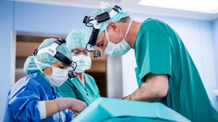 Ärzte und Pflegekraft untersuchen Patient mit einem Endoskop