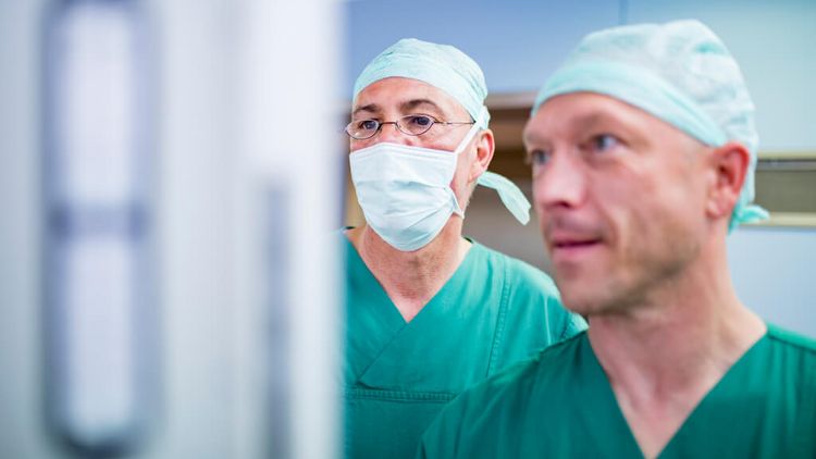 Zwei Ärzte überwachen eine HNO-Operation
