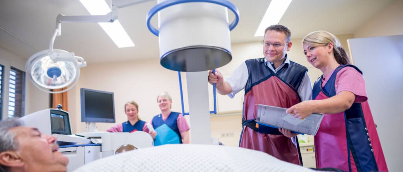 Arzt und Pflegekräfte bereiten Patienten in der Urologie für die Röntgenuntersuchung vor