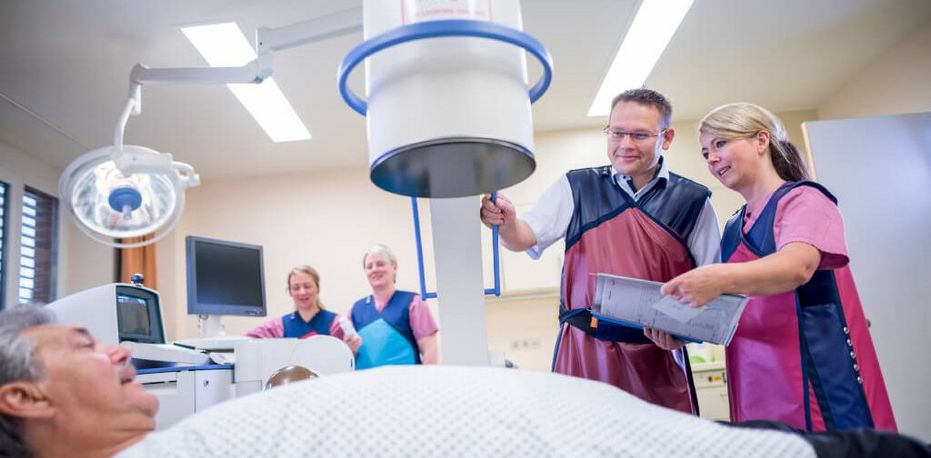 Arzt und Pflegekräfte bereiten Patienten in der Urologie für die Röntgenuntersuchung vor