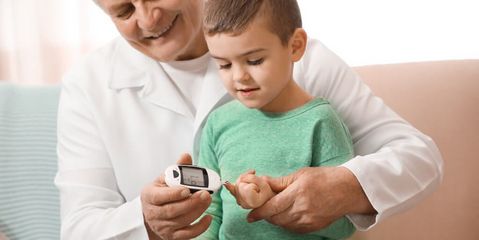 Arzt misst Blutzuckerspiegel bei einem kleinen Jungen
