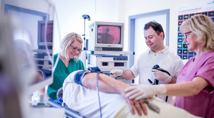 Arzt und Pflegekräfte untersuchen einen Patienten mit Gastroskopie